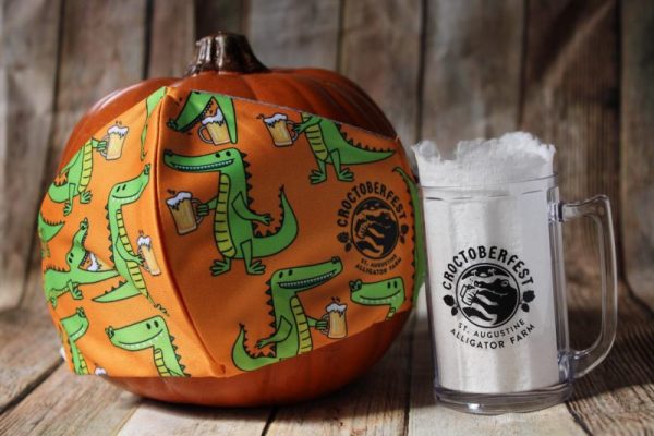 St. Augustine Alligator Farm celebrates Croctoberfest Brew at the Zoo 2020 with beer mug and pumpkin with themed alligator mask.