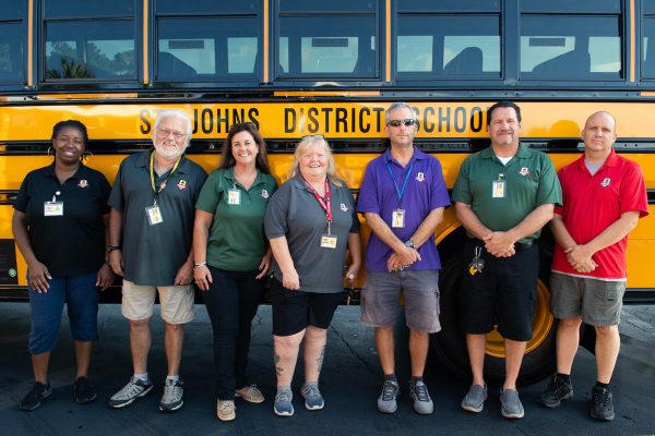 st johns county bus drivers stand in front of a school bus