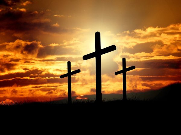 three crosses in front of a sunrise on easter morning
