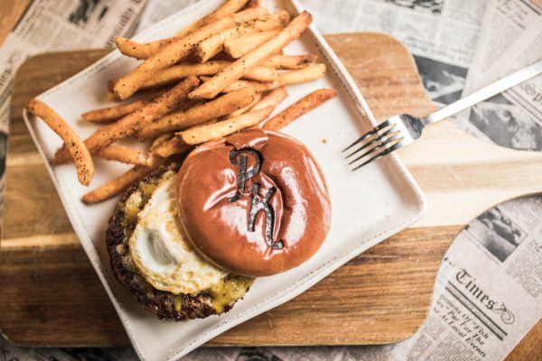 overhead shot of prohibition kitchen's burger with a fried egg and fries